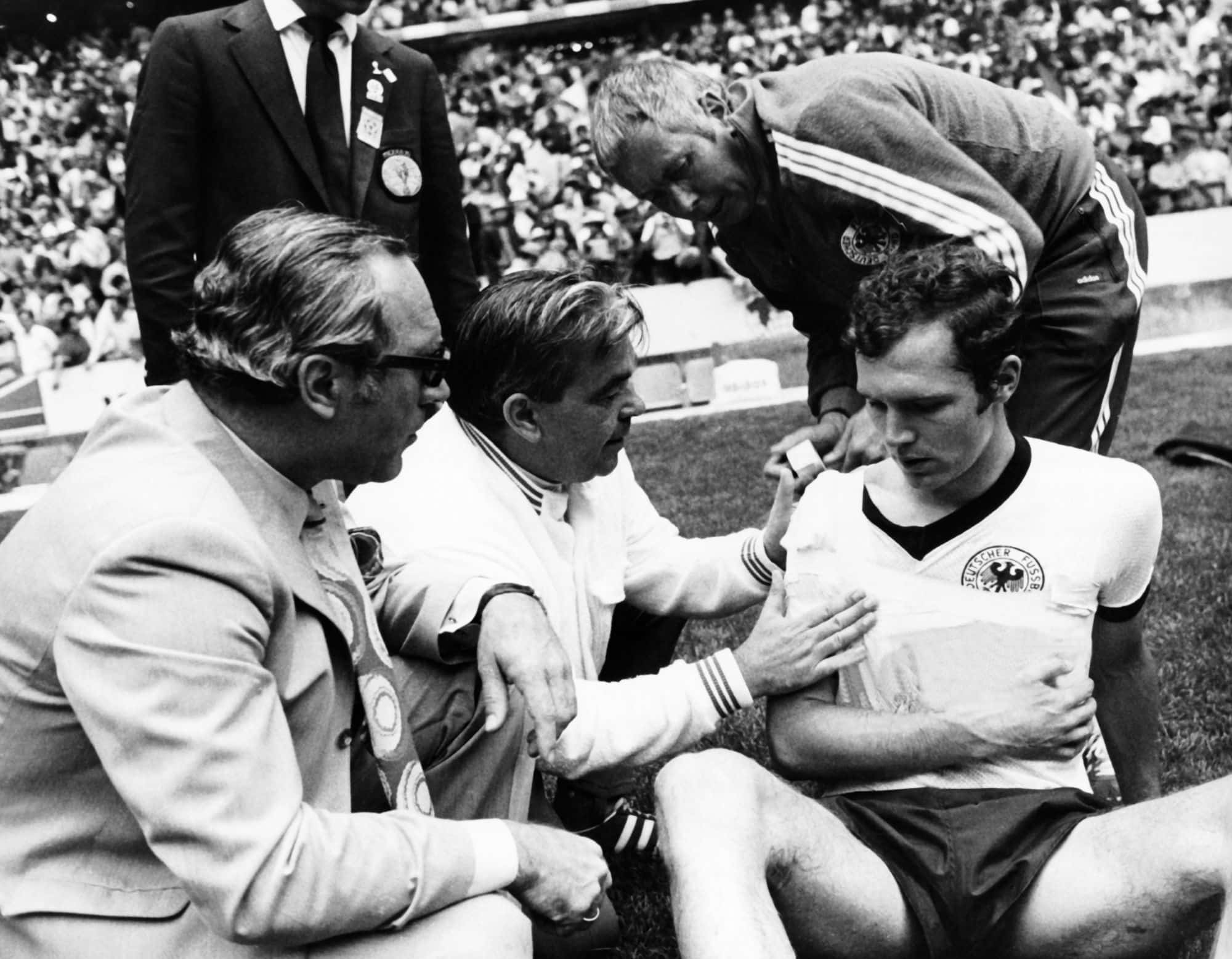  Franz Beckenbauer recebe os cuidado dos enfermeiros ap&oacute;s machucar seu ombro durante a semi-final da copa do mundo, contra a It&aacute;lia.